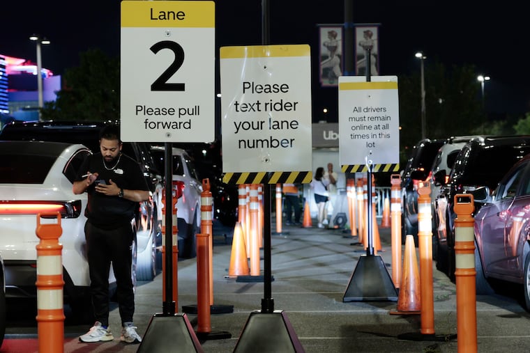 An Uber driver watches his phone while parked in Lot T after the Mets vs. Phillies game at Citizens Bank Park in Philadelphia in 2025.