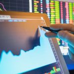 A professional trader using a stylus to interact with a rapidly rising stock chart displayed on a tablet.